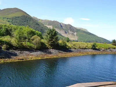 a body of water with mountains in the background at River Mill House in Ballachulish