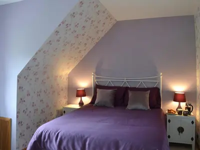 a bedroom with a bed with a purple bedspread at River Mill House in Ballachulish