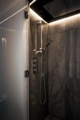 a bathroom with a shower with a glass door at The Alamo Guest House in Glasgow
