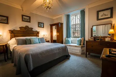 a bedroom with a bed and a sink and a window at The Alamo Guest House in Glasgow