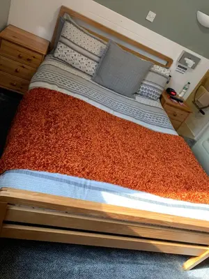 a large bed with a wooden frame in a room at Greenacre in Oban