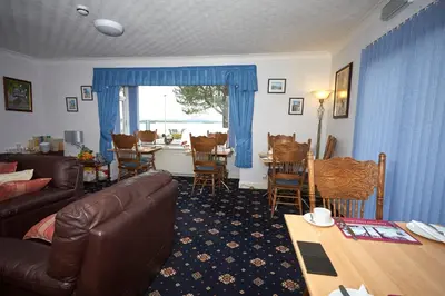a living room with a couch and a table and chairs at Greenacre in Oban