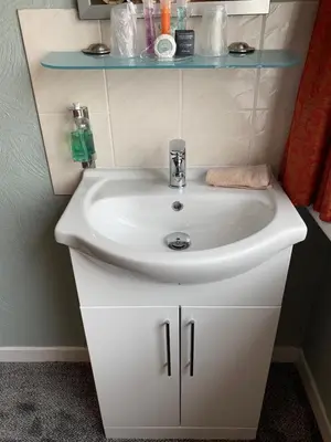 a bathroom with a white sink and a blue shelf at Greenacre in Oban