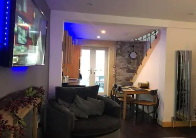 a living room with a couch and a table at Ayrshire Holiday Cottage in Girvan