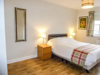 a bedroom with a bed and a dresser and a mirror at Holiday Home Devonvale Place by Interhome in Kinross