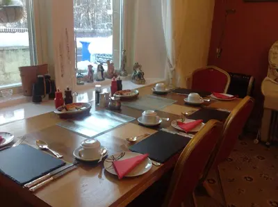 a wooden table with chairs and plates and dishes on it at glenardran house in Crianlarich