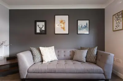 a gray couch in a living room with pictures on the wall at Dunfermline - Luxury Two Bedroom Apartment - TP in Dunfermline