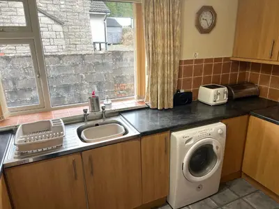 a kitchen with a sink and a washing machine at Feorline Cottage in Lochgoilhead