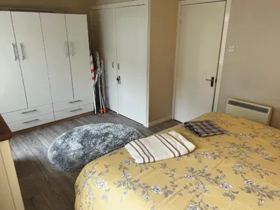 a bedroom with a bed and white cabinets at Feorline Cottage in Lochgoilhead