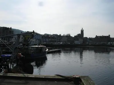 a boat is docked at a dock in a body of water at Knap Guest House in Tarbert