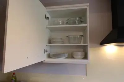 a kitchen cabinet with plates and bowls in it at Blairmains Guest House in Kirk of Shotts