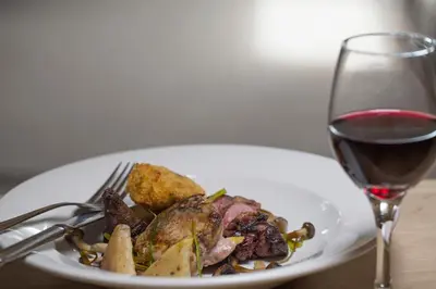a plate of food next to a glass of wine at Bridgend Hotel in Bridgend