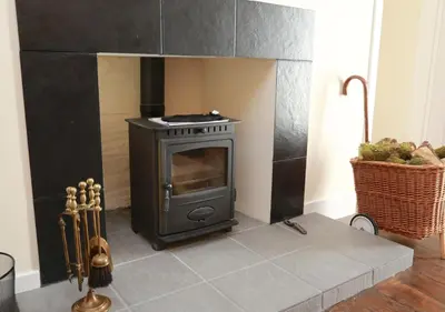a stove in a kitchen with a basket of fruit at Ivybank Cottage in Lochgoilhead