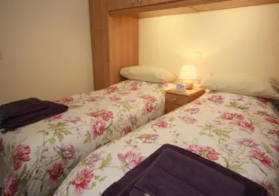 two beds sitting next to each other in a bedroom at Ivybank Cottage in Lochgoilhead