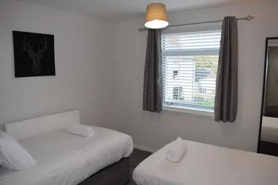 a bedroom with two twin beds and a window at 3 Bedroom-Kelpies Serviced Apartments Burns in Falkirk