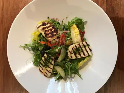 a white plate with a salad with chicken and vegetables at Rab Ha's in Glasgow