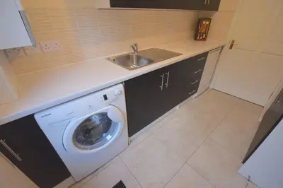 a kitchen with a washing machine and a sink at Ashburn Cottage in Lochgoilhead