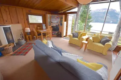 a living room with blue couches and a fireplace at Dalriada by Loch Goil in Carrick