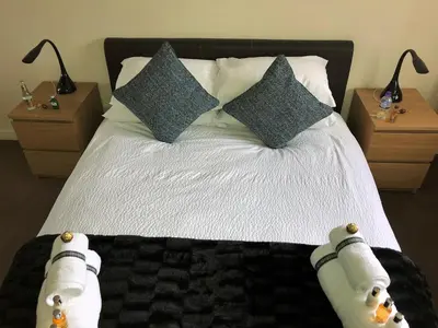 a bedroom with a bed with pillows and two night stands at Castle Gait, Paisley in Paisley