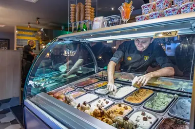 a man is preparing food in a food truck at The Raven’s Cliff Lodge by Marston's Inns in Motherwell