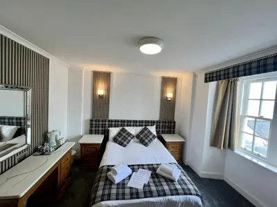 a bedroom with a bed and a sink and a mirror at The Grey Gull Hotel in Ardrishaig