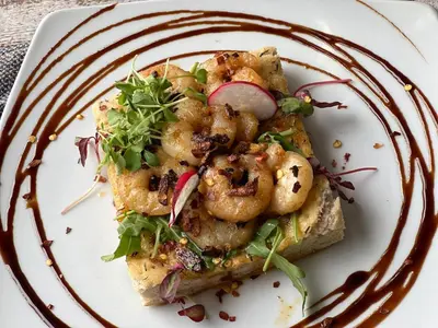 a plate of food with shrimp and greens on it at The Grey Gull Hotel in Ardrishaig