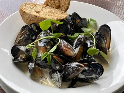 a plate of mussels and a slice of bread at The Grey Gull Hotel in Ardrishaig