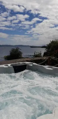 a bath tub filled with water next to a body of water at The Grey Gull Hotel in Ardrishaig