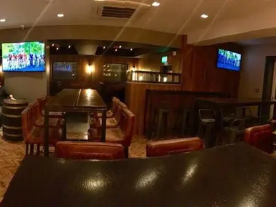 a bar with a table and chairs and televisions at Oxgang Kitchen Bar & Rooms in Grangemouth