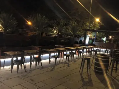 a row of tables and chairs on a patio at night at Oxgang Kitchen Bar & Rooms in Grangemouth