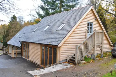 a small house with a gambrel roof and a staircase at Finlaystone Barns in Port Glasgow