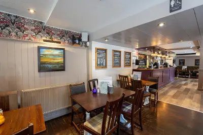 a dining room with wooden tables and chairs at West Port Hotel in Linlithgow
