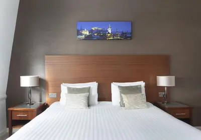 a bedroom with a large white bed with two lamps at Stewart by Heeton Concept - Aparthotel Edinburgh in Edinburgh