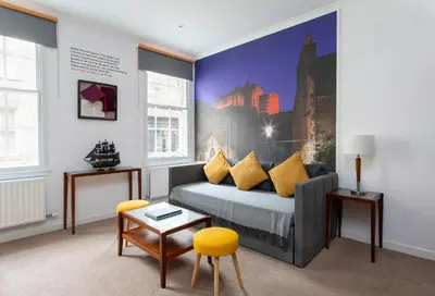 a bedroom with a bed with yellow pillows at Stewart by Heeton Concept - Aparthotel Edinburgh in Edinburgh