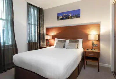 a hotel room with a large bed and two lamps at Stewart by Heeton Concept - Aparthotel Edinburgh in Edinburgh
