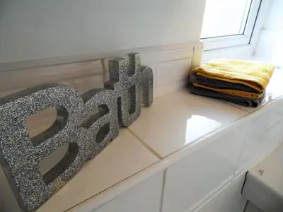 a metal sign sitting on top of a white dresser at Signature - Brambling House in Coatbridge