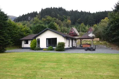 a white house with a gazebo in a yard at Crann Mhor Holiday Home in Lochgoilhead