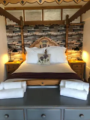 a bedroom with a large bed with a wooden headboard at loch lomond apartments in Alexandria