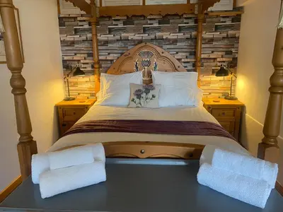 a bedroom with a large bed with two night stands at loch lomond apartments in Alexandria
