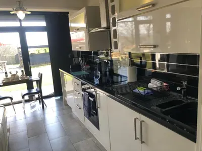 a kitchen with a black counter top and a table at loch lomond apartments in Alexandria