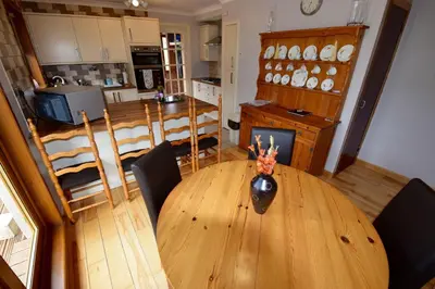 a kitchen and dining room with a wooden table and chairs at Cobbler View No. 1 in Lochgoilhead