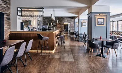 a bar in a restaurant with tables and chairs at The Scot in Oban