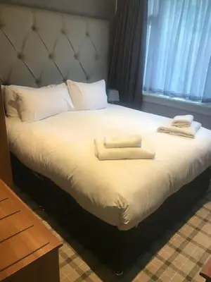 a bed with two towels on top of it at The Scot in Oban