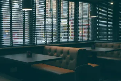 a restaurant with two tables and a bench and windows at The Scot in Oban