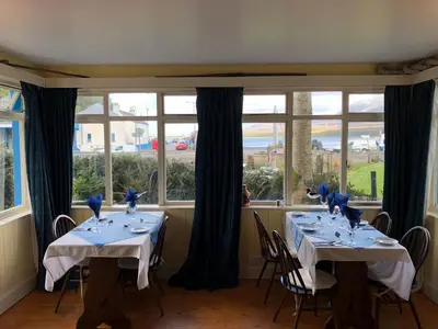 a dining room with two tables with blue birds on them at Port Askaig Hotel in Port Askaig
