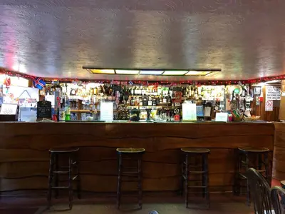 a bar with two bar stools in front of it at Port Askaig Hotel in Port Askaig