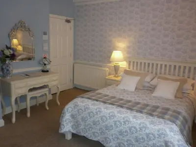 a bedroom with a bed and a table and a desk at Comelybank Guesthouse in Crieff