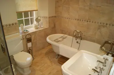 a bathroom with a tub and a toilet and a sink at Comelybank Guesthouse in Crieff