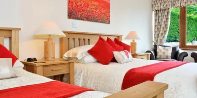 a bedroom with two beds with red pillows at Peggyslea Farm B&B in Edinburgh