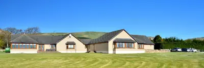 a house with a grass yard in front of it at Peggyslea Farm B&B in Edinburgh